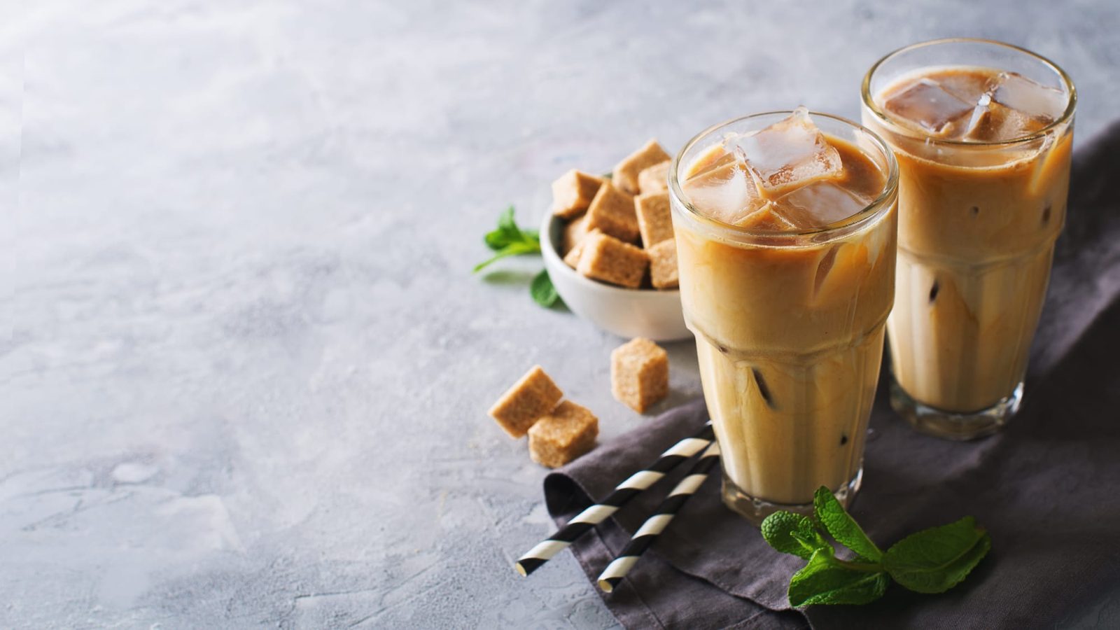 Two iced coffees on a stone table